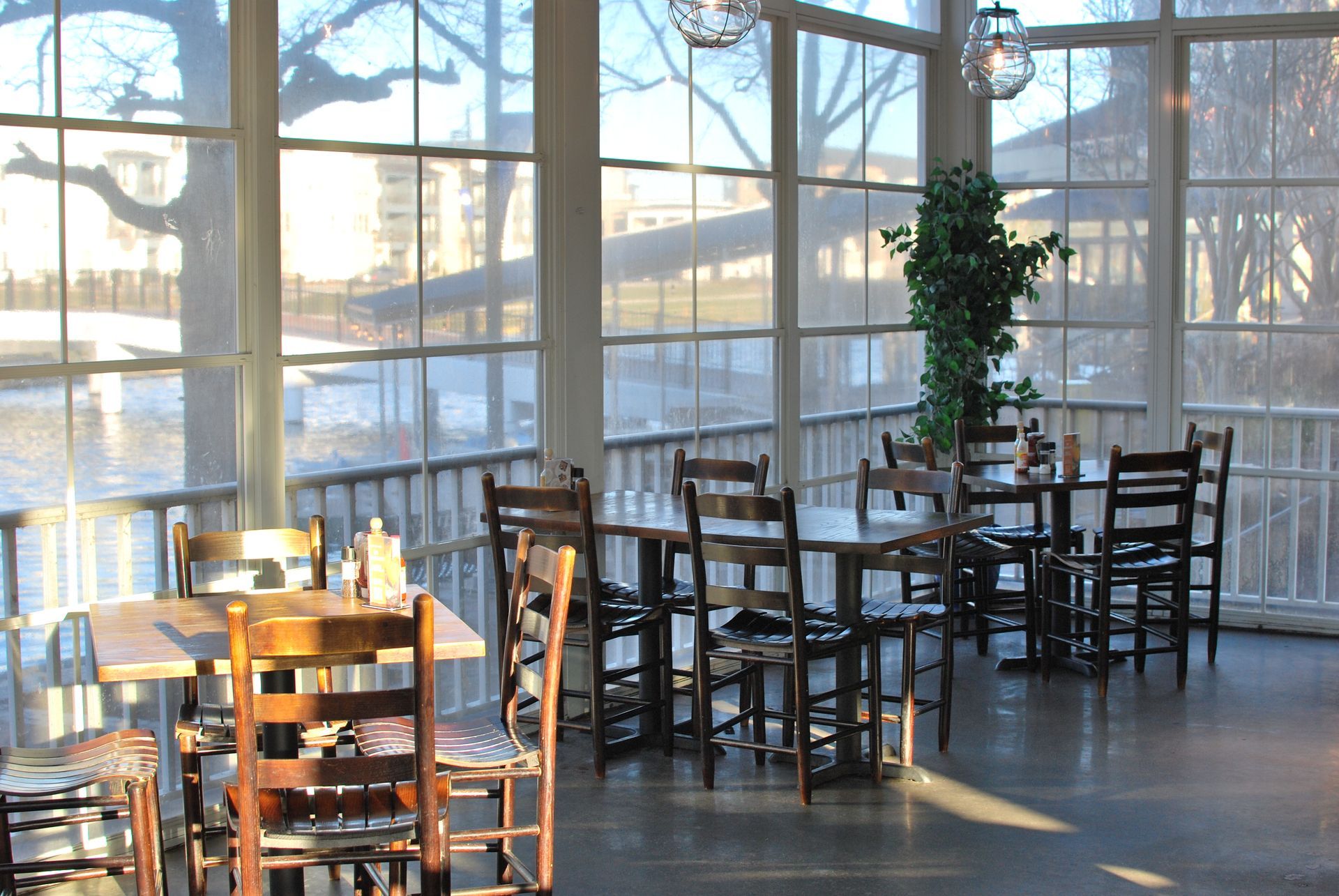 A restaurant with tables and chairs with a view of a river