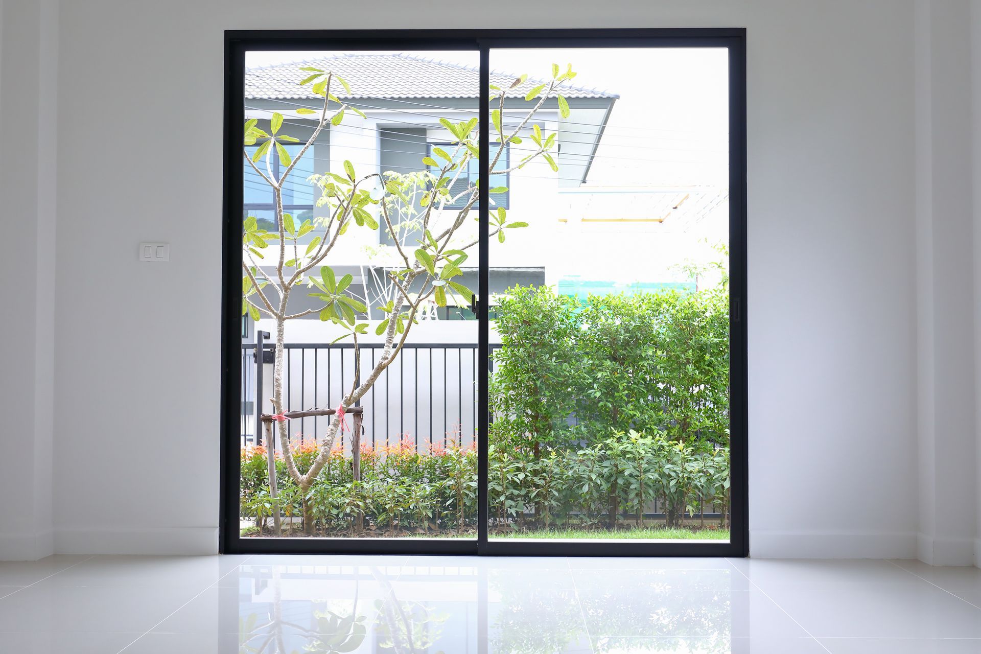 A glass sliding door revealing a small outdoor patio