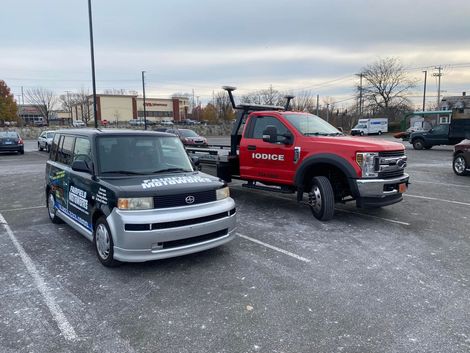 Fairfield Motoworks service vehicle parked next to a red tow truck in a parking lot | Fairfield Motoworks LLC