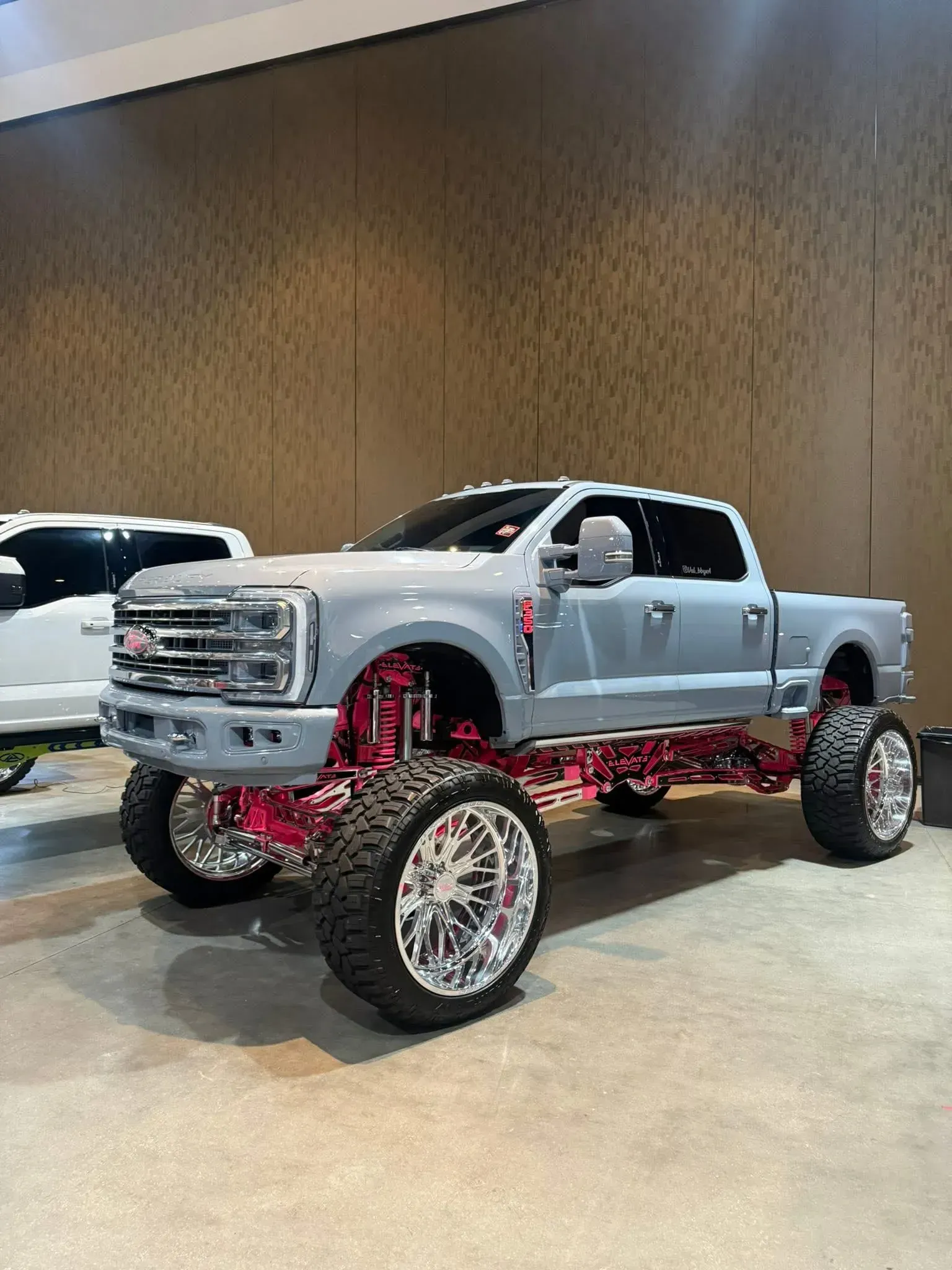 Gray lifted truck with pink accents and chrome wheels.