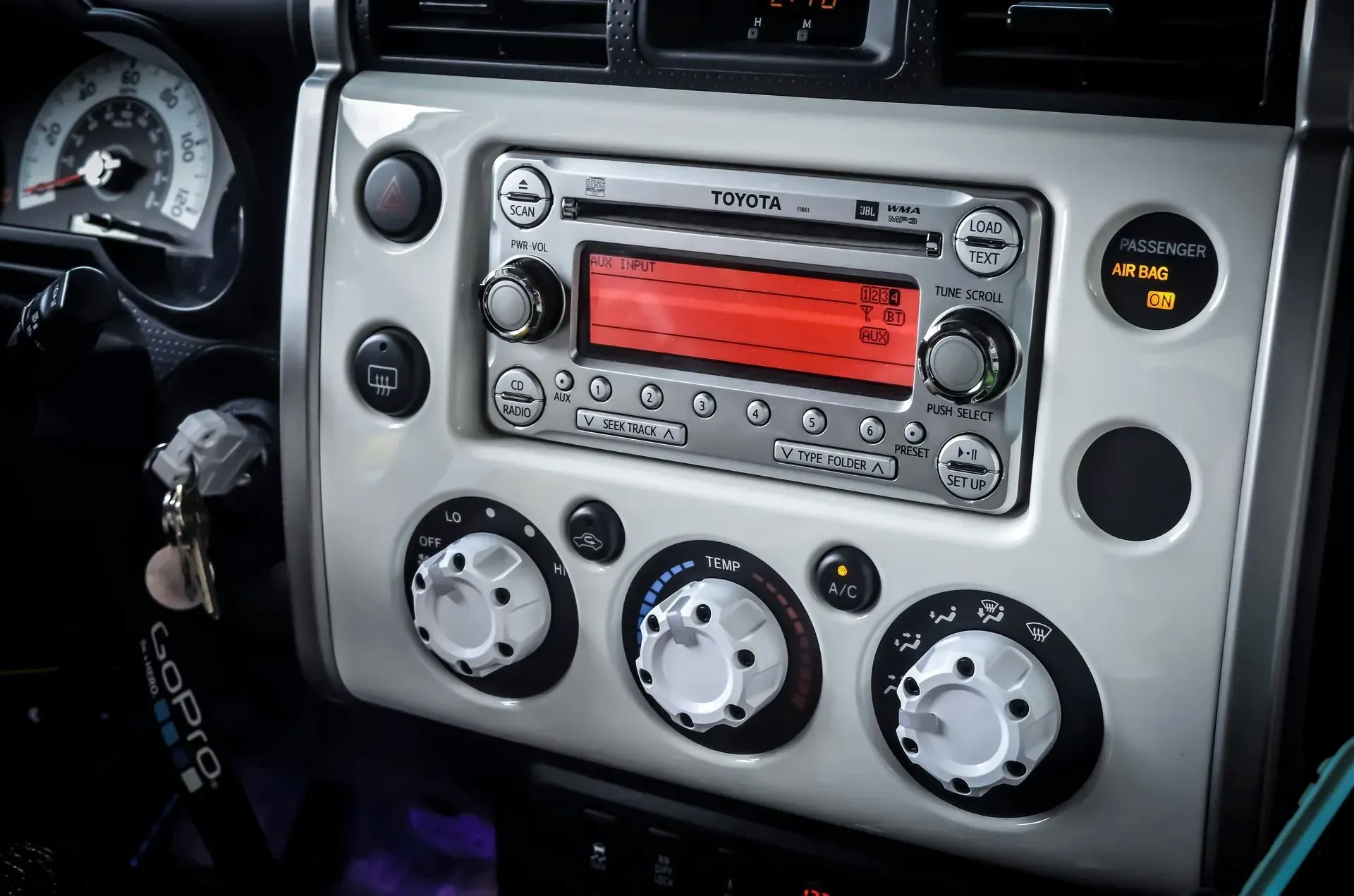 Car dashboard with radio and climate controls; silver and black.