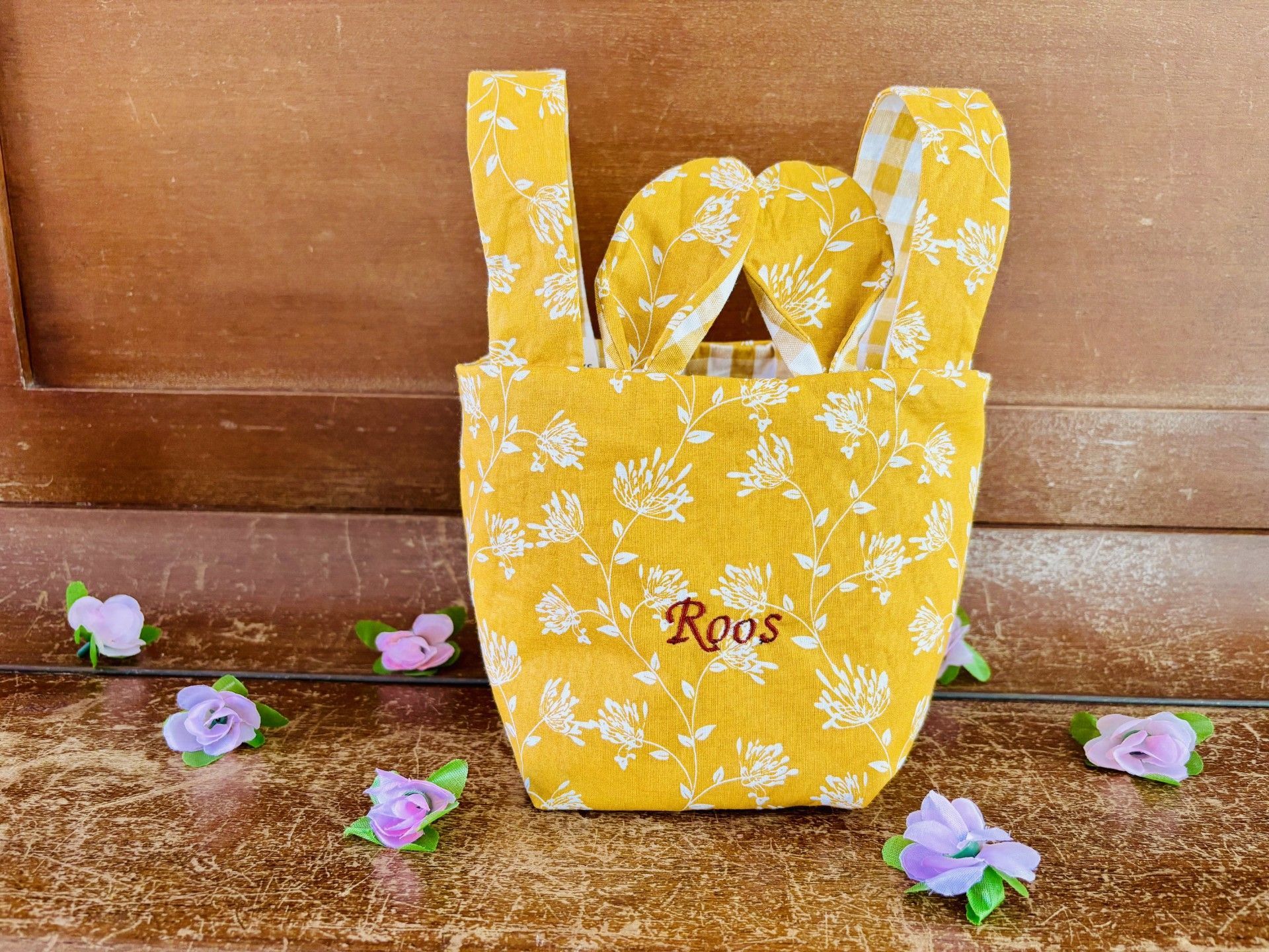 geel Paasmandje met daarop de naam Roos. 2 hengsels en konijnenoortjes