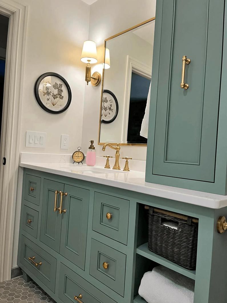 A bathroom with a sink , mirror , cabinets and drawers.
