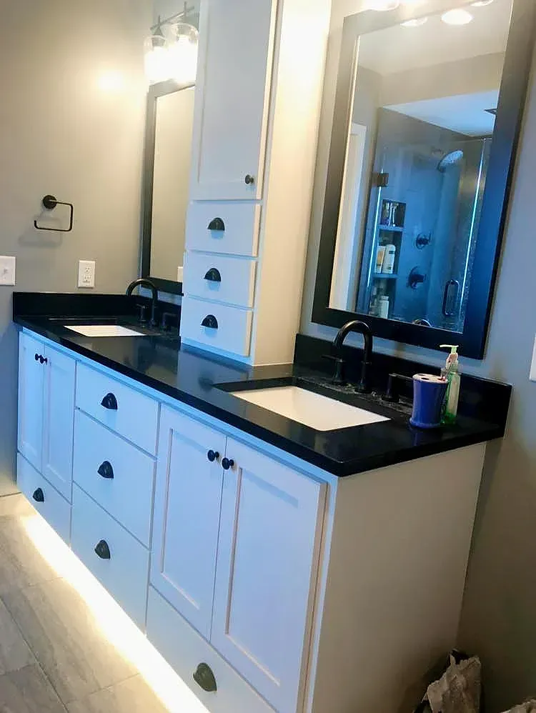 A bathroom with two sinks and a large mirror