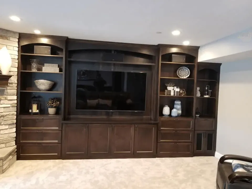A living room with a large entertainment center and a flat screen tv.