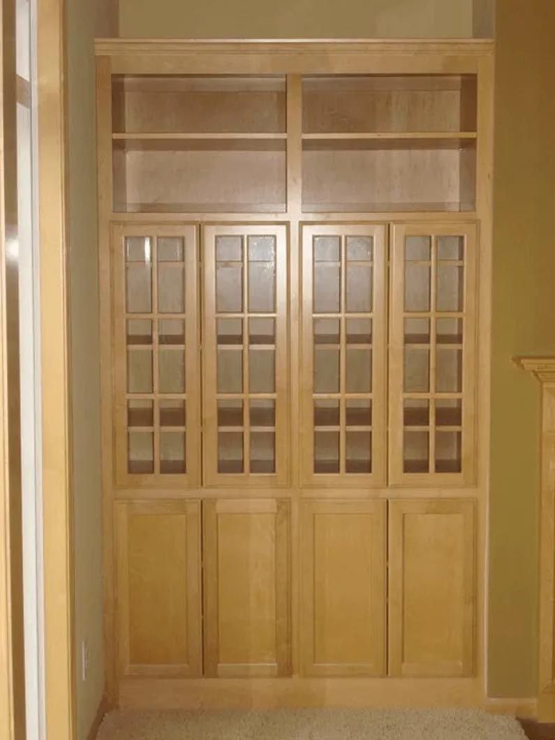 A wooden cabinet with glass doors and shelves