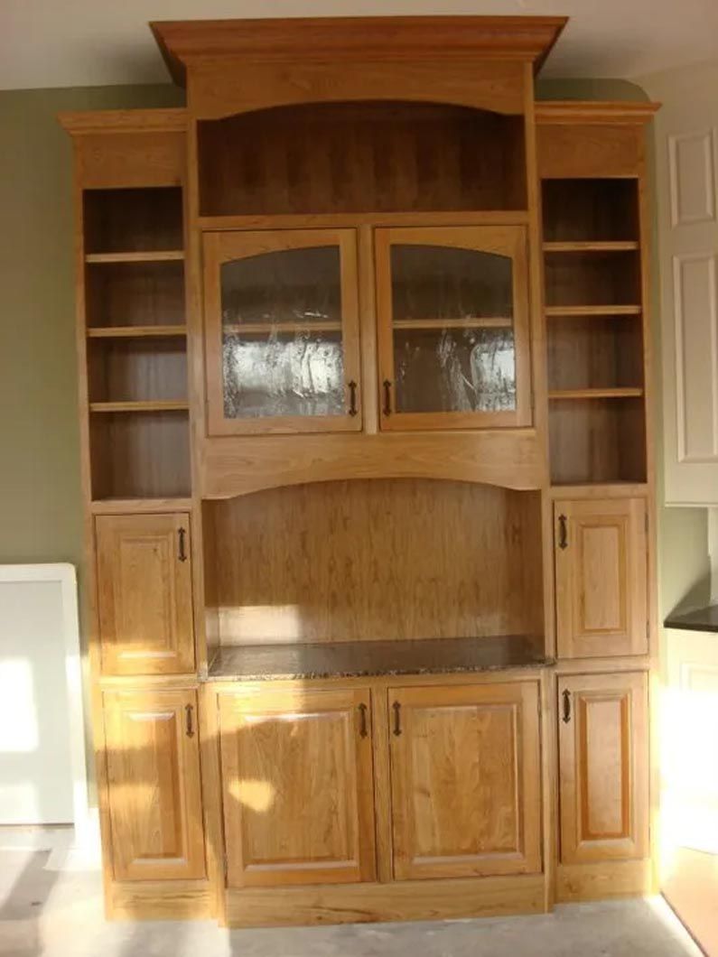 A large wooden cabinet with glass doors and shelves