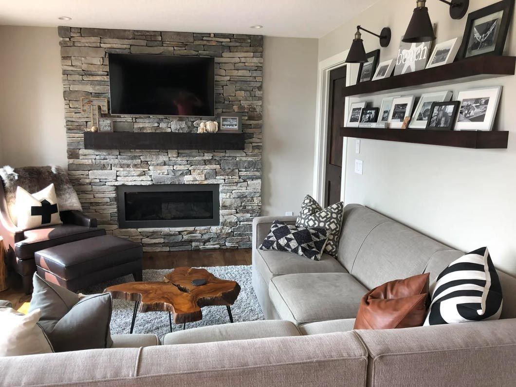 A living room with a couch , fireplace and television.