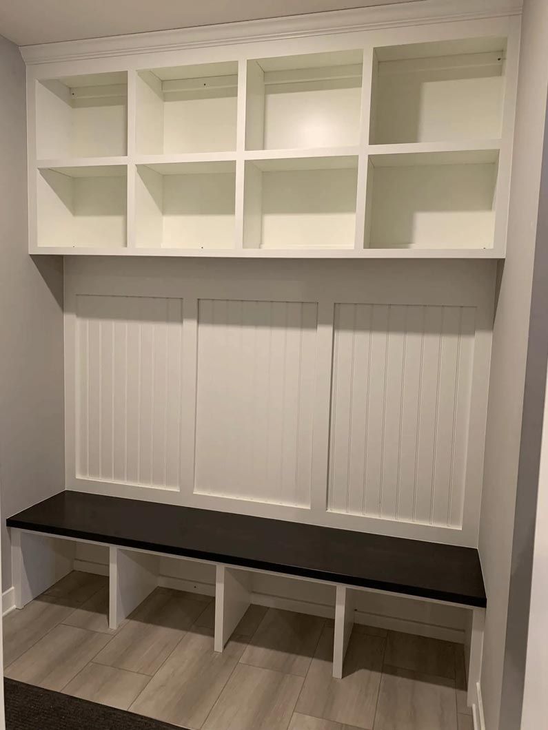 A room with a bench and shelves in it.