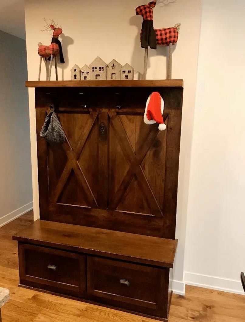 A room with a wooden bench and a shelf with a santa hat on it.