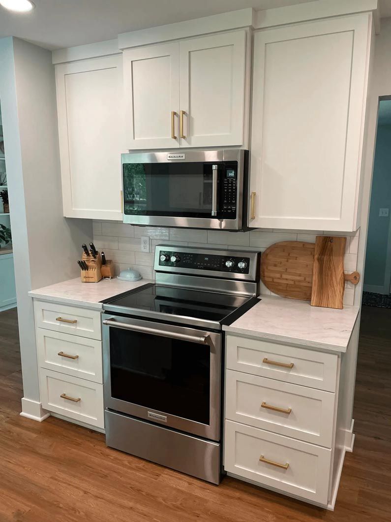 A kitchen with stainless steel appliances and white cabinets.