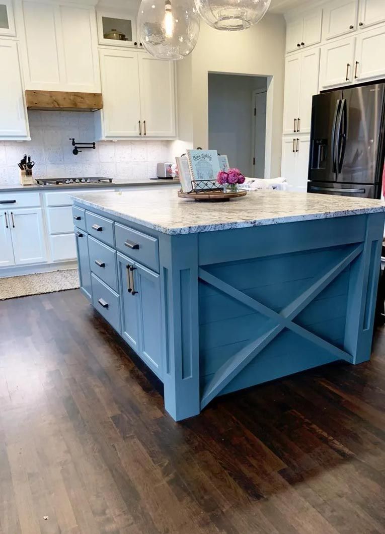 There is a large blue island in the middle of the kitchen.