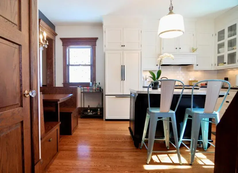 A kitchen with a table and chairs and a refrigerator.