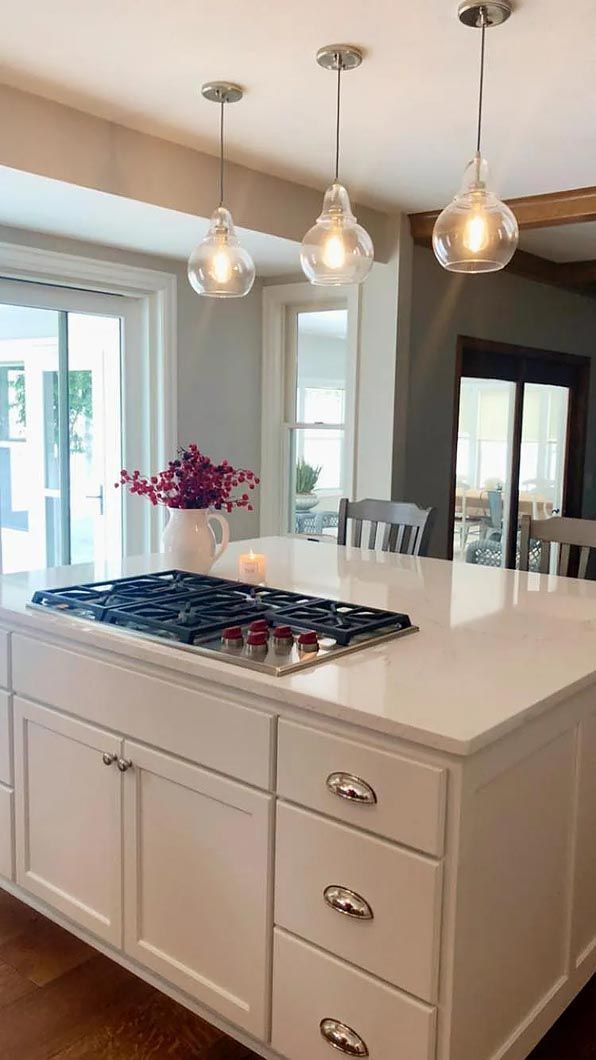 A kitchen with a large island and a stove top oven.