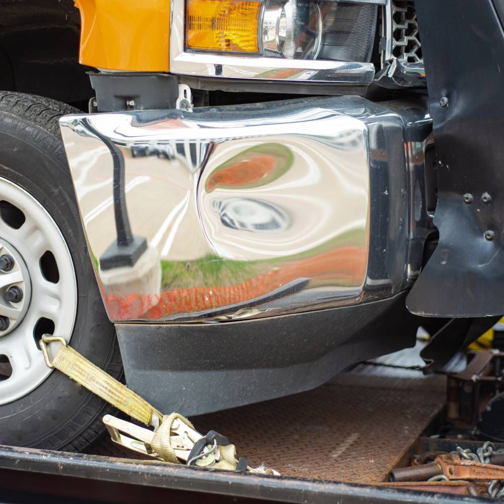 A truck is being towed by a tow truck