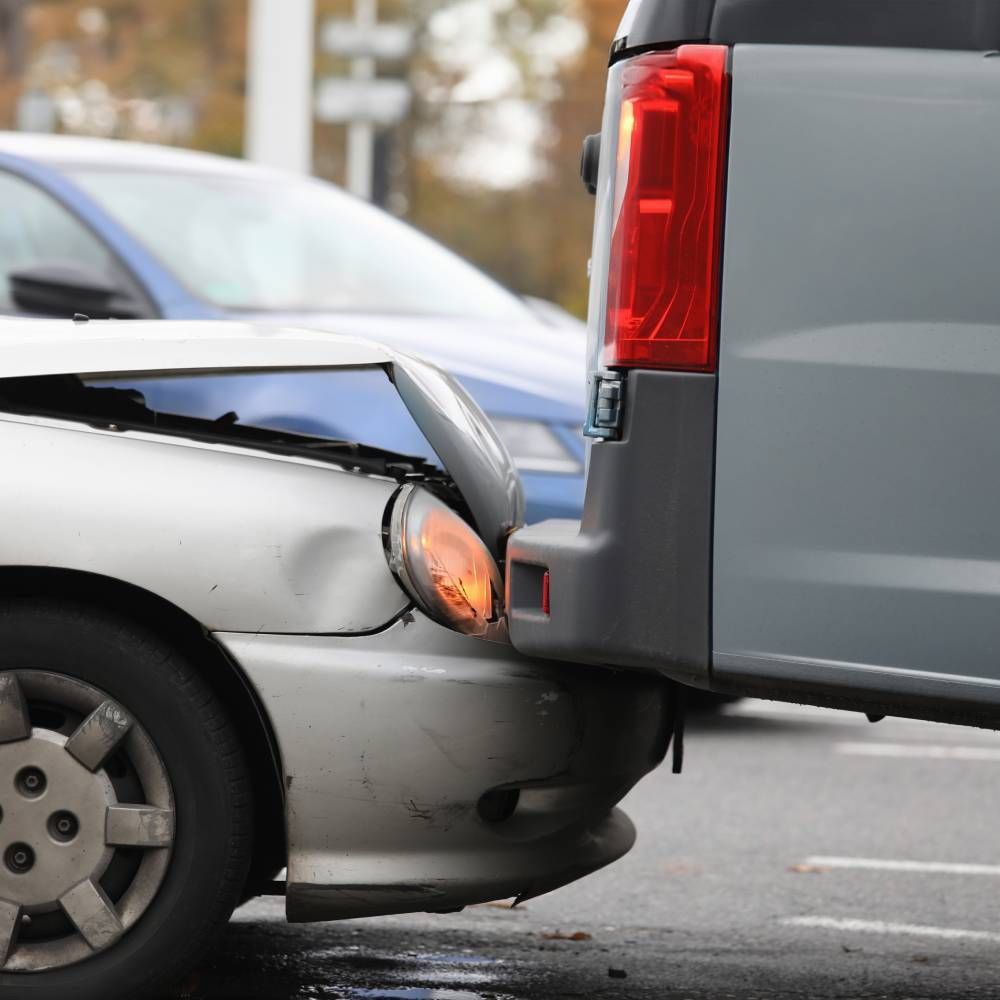 A silver car has been damaged by a gray van