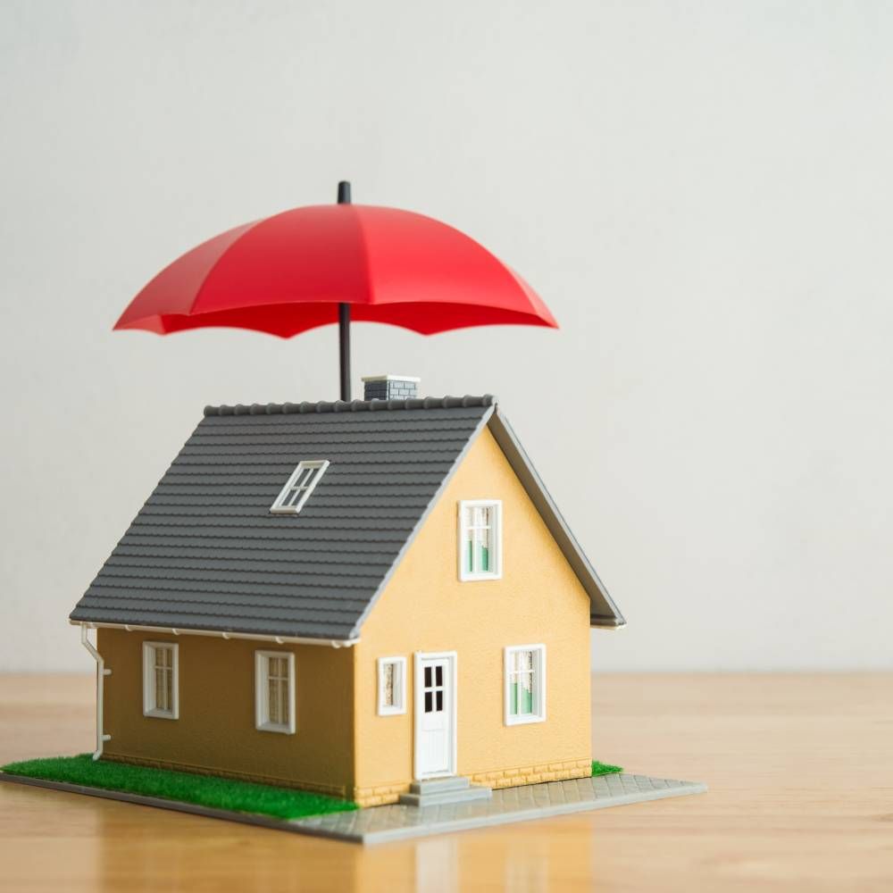 A model house with a red umbrella on top of it