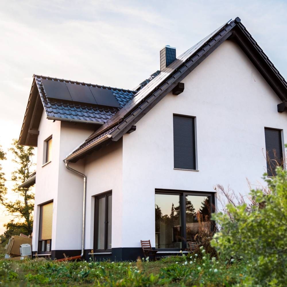 A white house with solar panels on the roof