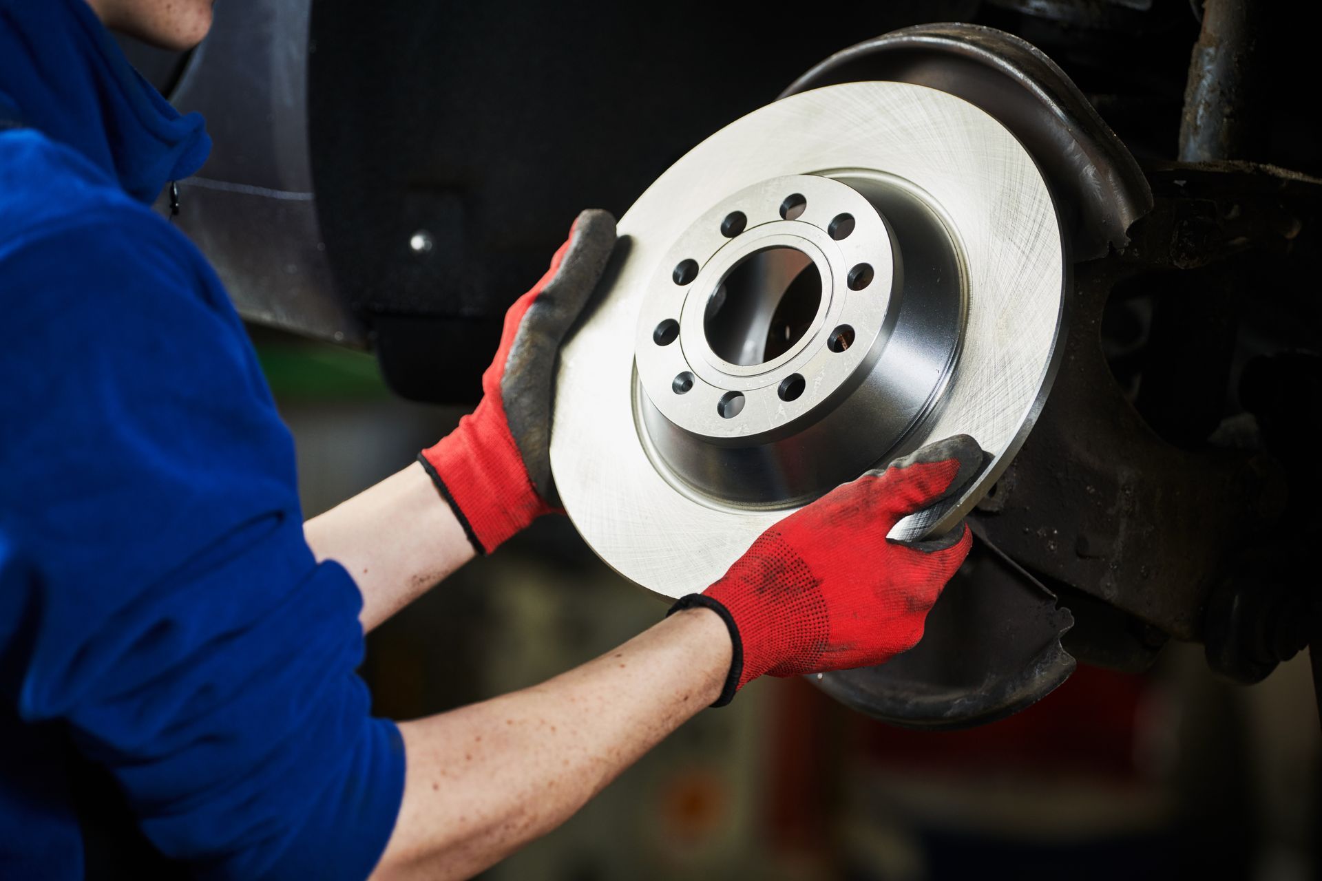 A mechanic performs an auto brake repair service, replacing a brake disk on a car.