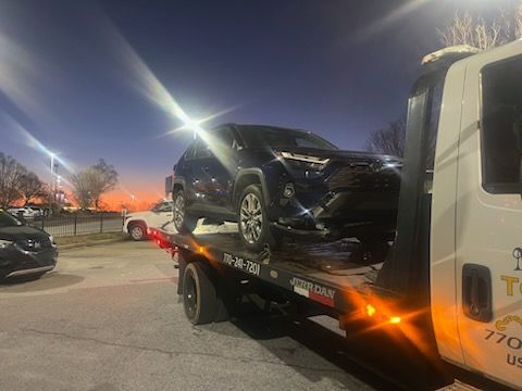 A car is being towed by a tow truck.