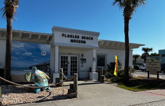 Flagler Beach Museum entrance with palm trees and ocean mural on a sunny day