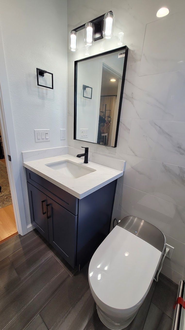 A bathroom with a sink , toilet and mirror.