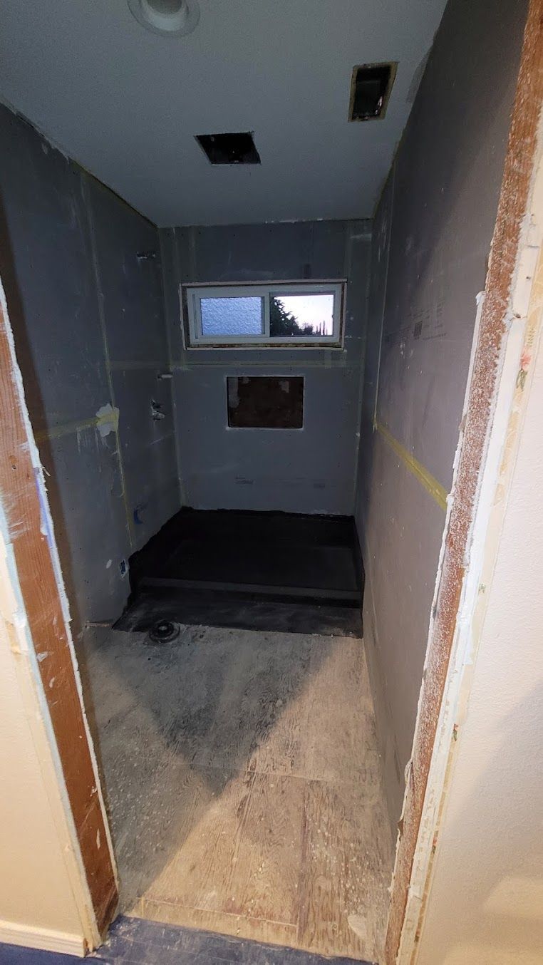 A bathroom under construction with a window and a door.