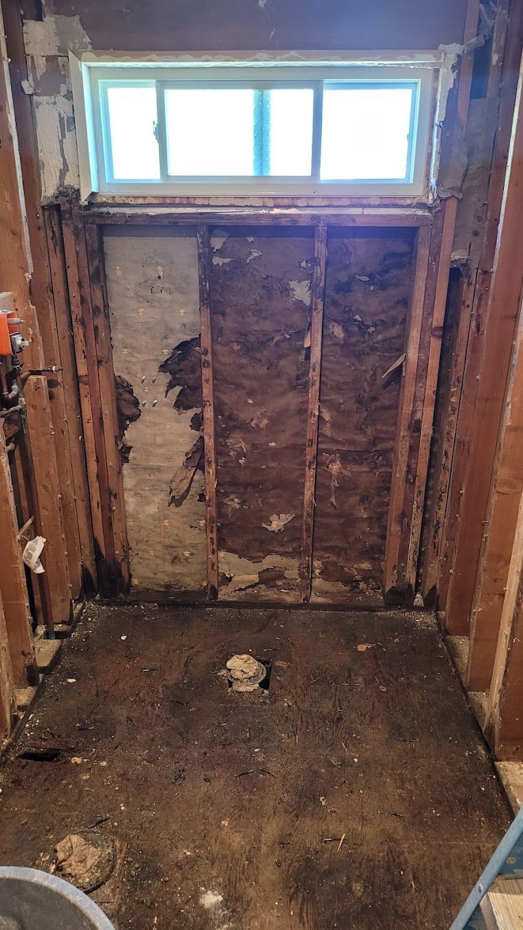 A bathroom is being remodeled with a window.