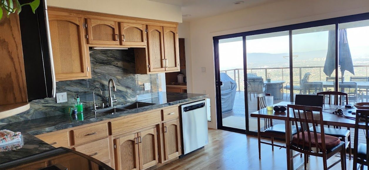 A kitchen and dining room with sliding glass doors leading to a balcony.