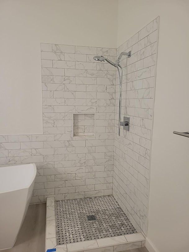 A bathroom with a walk in shower and a bathtub.