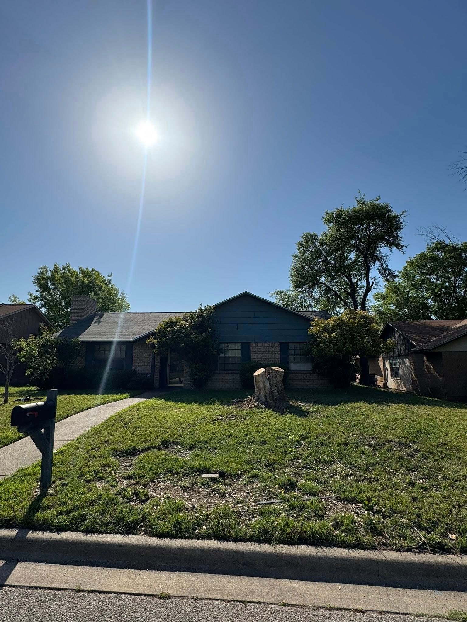 A house with a mailbox in front of it on a sunny day.