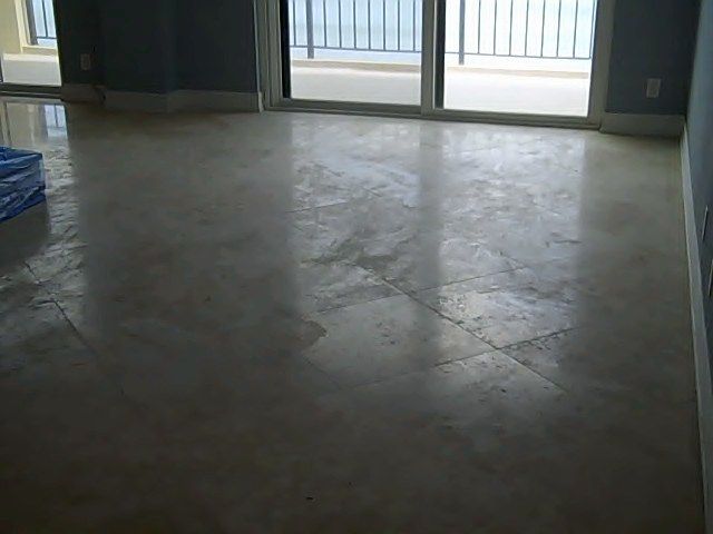 Polished, light-colored stone floor reflecting light