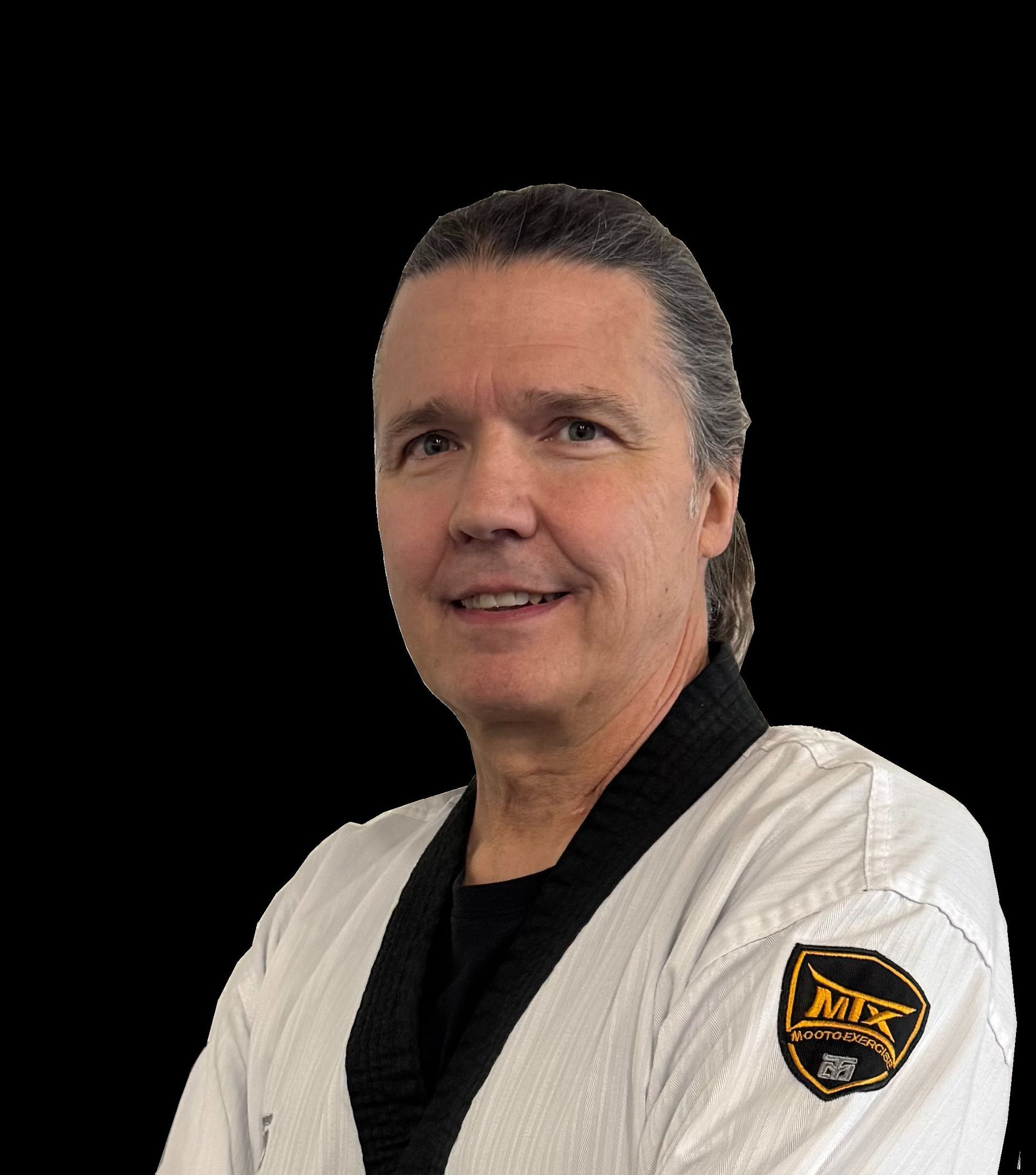 Man in martial arts uniform smiles, black belt, Apex logo, black background.