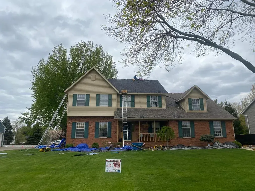 A Large Brick House with Green Shutters Is Being Painted | Fayetteville, NC | Danny Odom Roofing