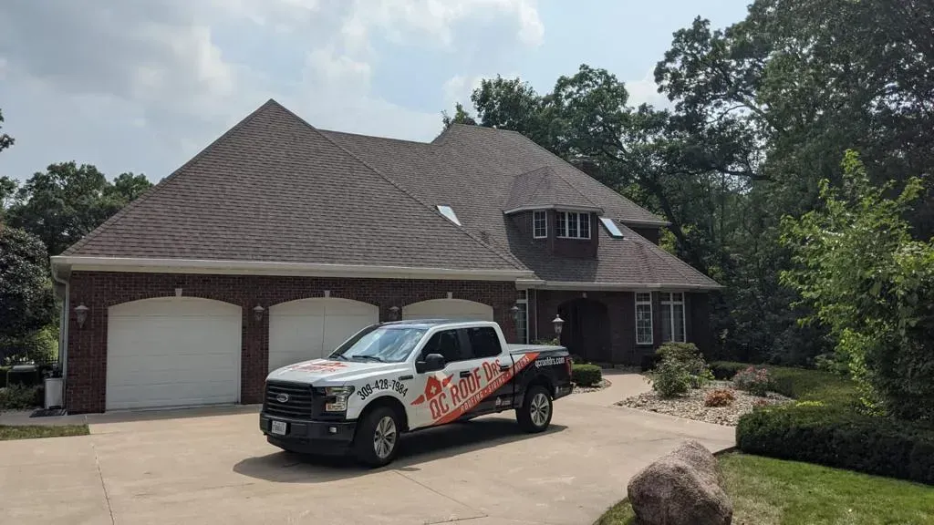 A White Truck Is Parked in Front of A Large Brick House | Fayetteville, NC | Danny Odom Roofing