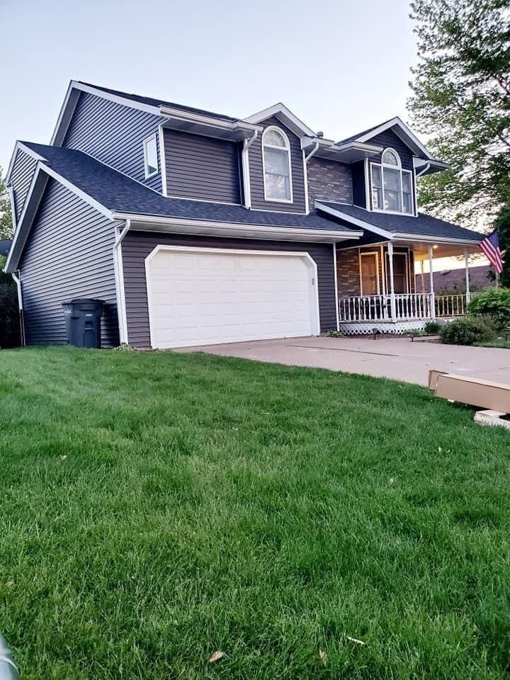 A Large House with A White Garage Door and A Large Lawn in Front of It | Fayetteville, NC | Danny Odom Roofing