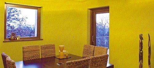 stanza con parete gialla e sedie in sughero