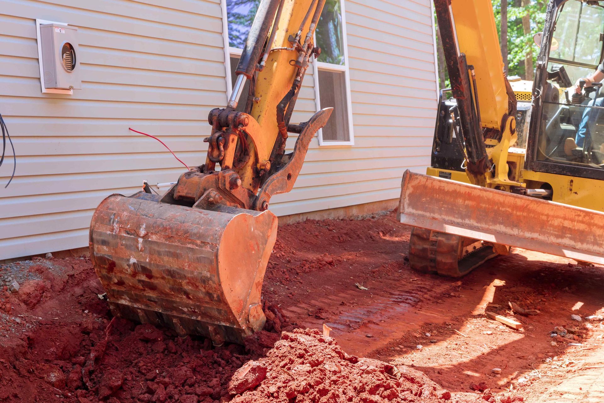 Excavator Moving Soil Next To Home For Foundation Work