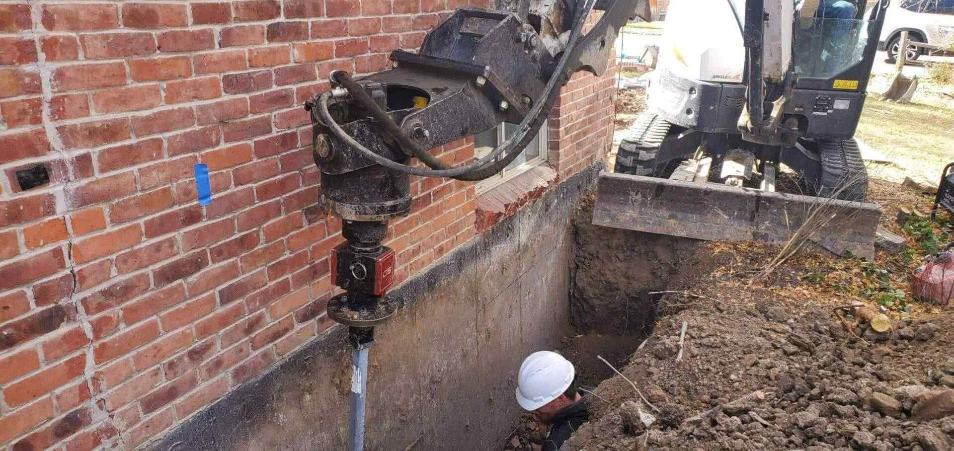 Helical Pier Installation In Hole By Excavator For House Foundation