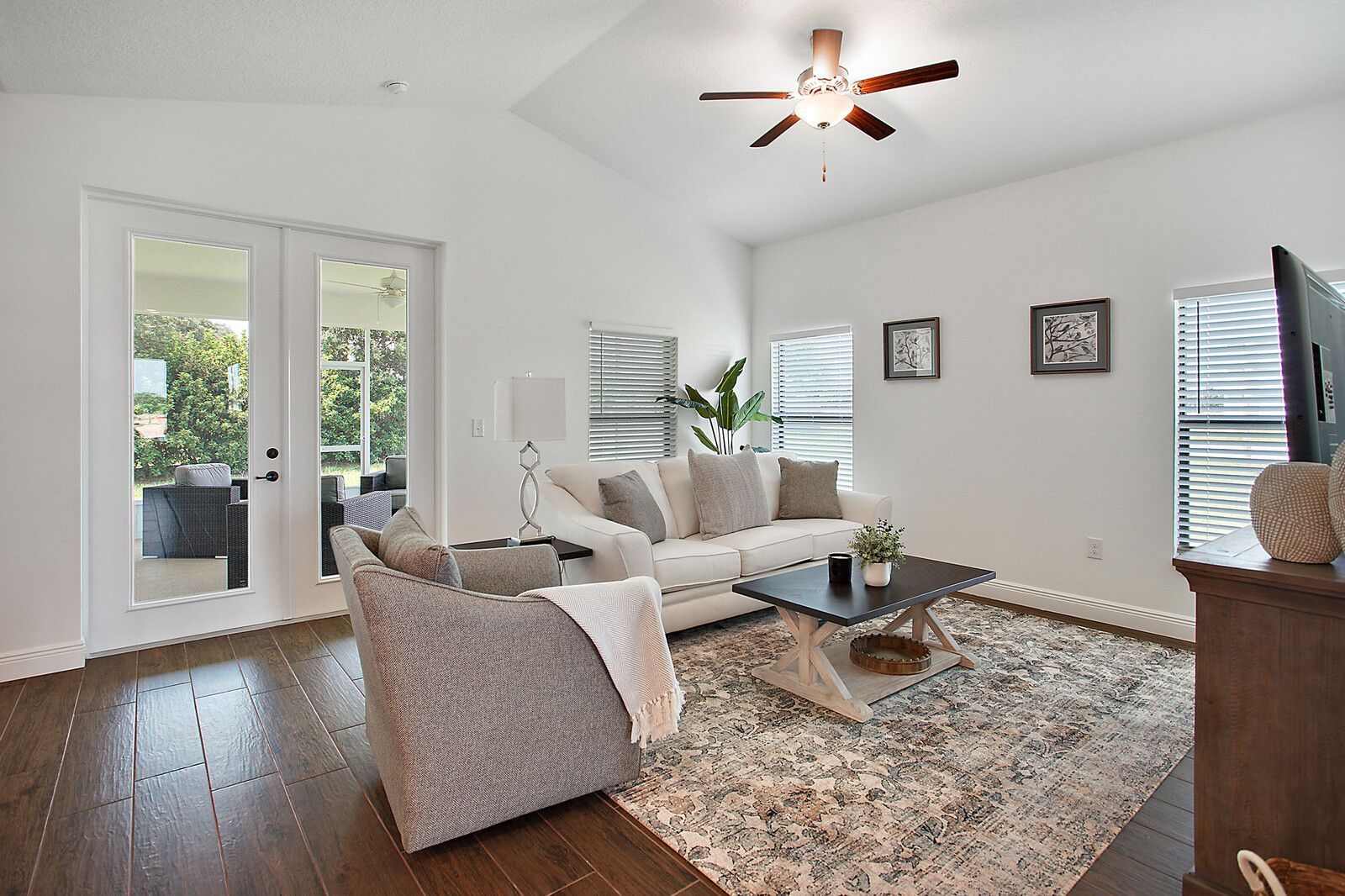 A living room with a couch , chair , coffee table and television.