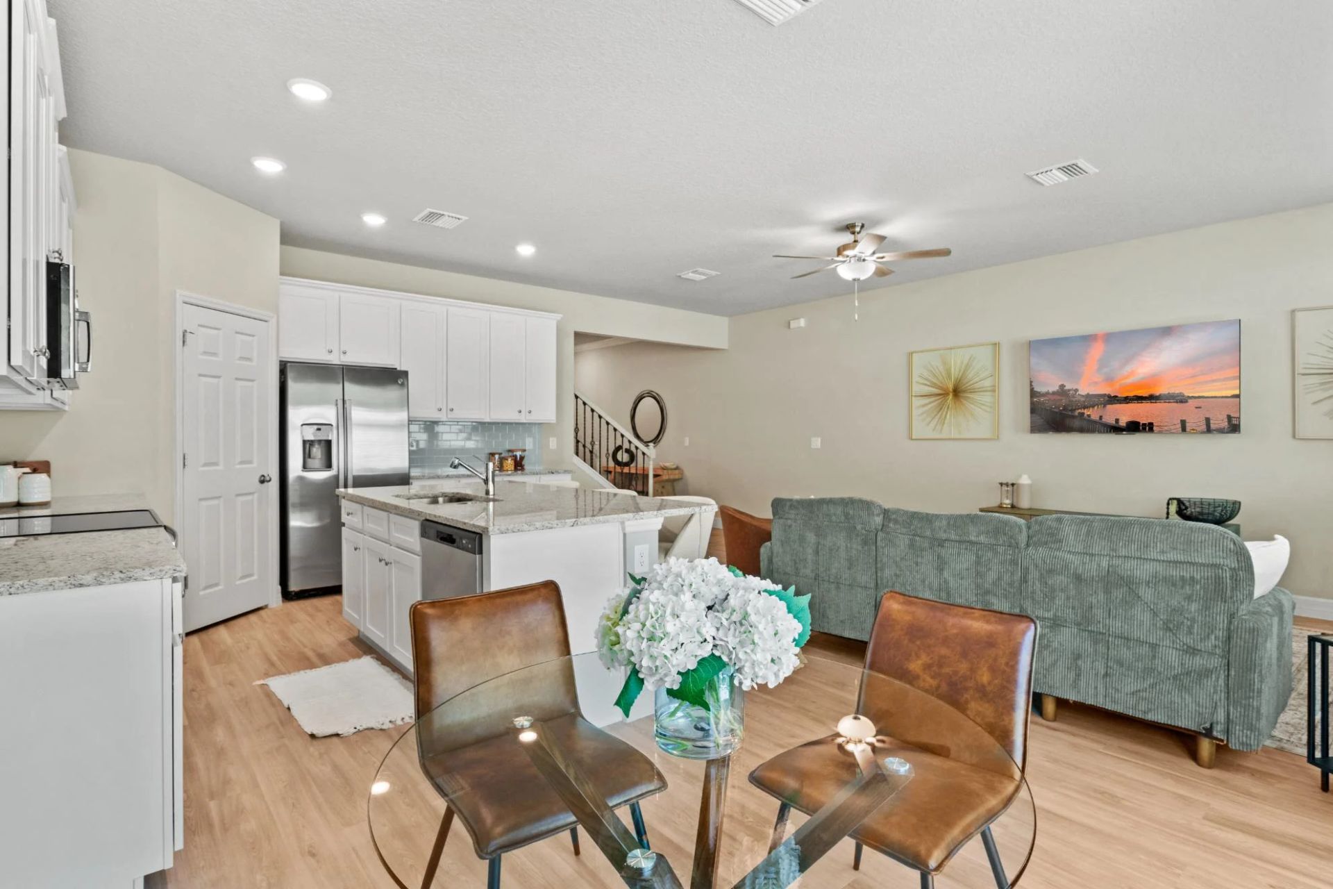A living room with a dining table and chairs and a kitchen.