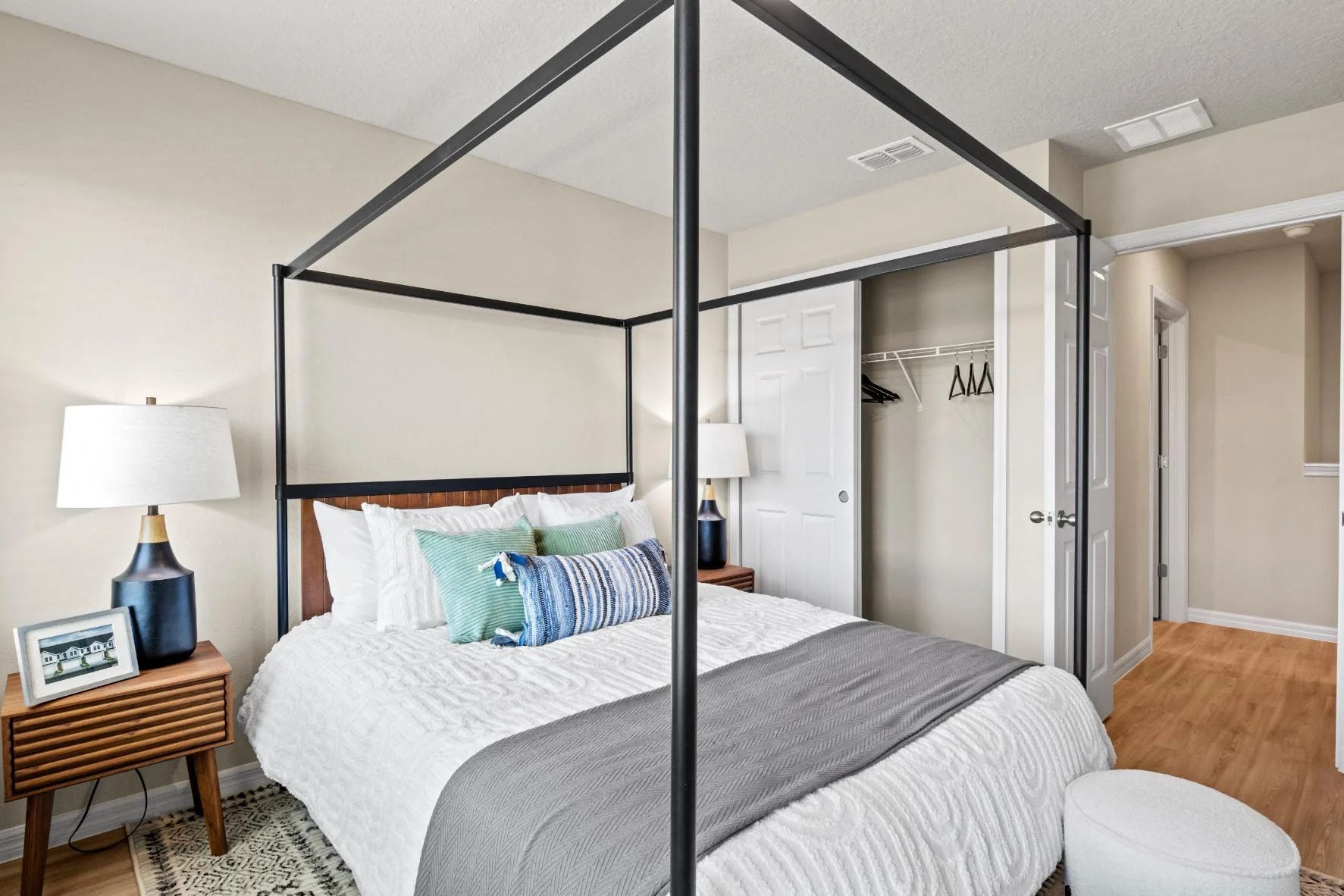 A bedroom with a canopy bed and a nightstand.