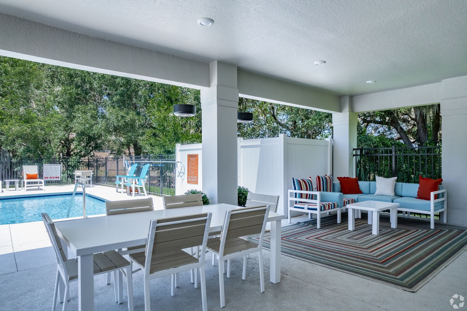 A patio with a table and chairs next to a pool