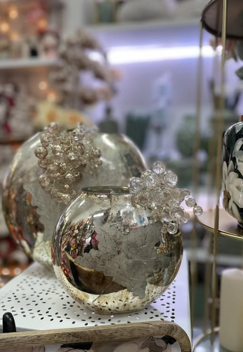 Due vasi sferici in vetro al mercurio con decorazioni in cristallo esposti in un negozio.