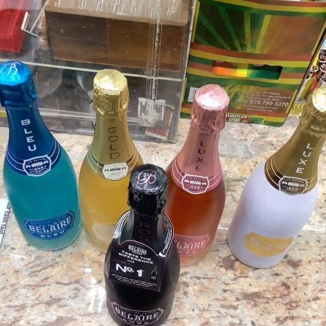 Several bottles of belaire champagne are lined up on a counter