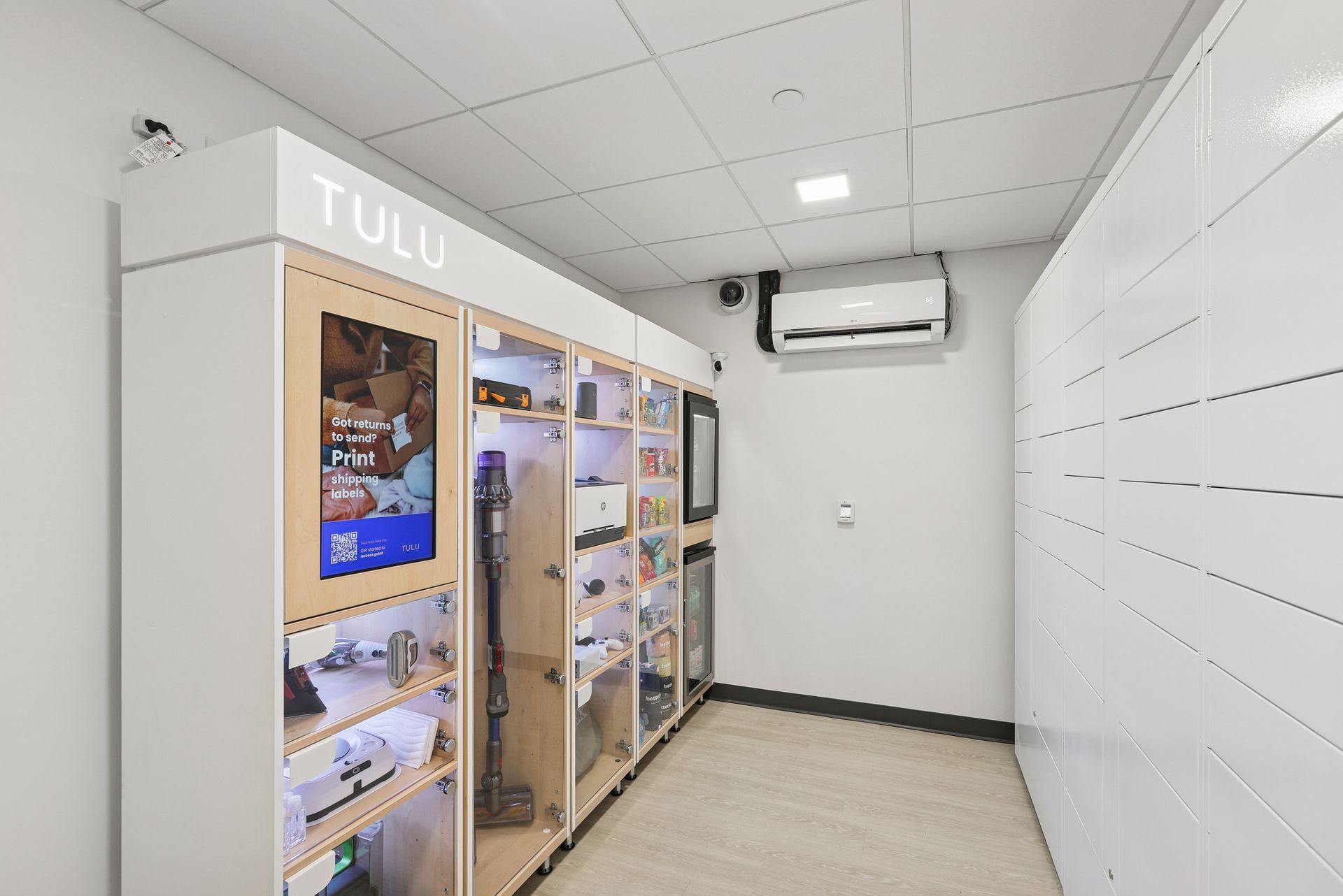 TULU tool-sharing cabinet in a white room with various tools visible. Air conditioner on the wall.