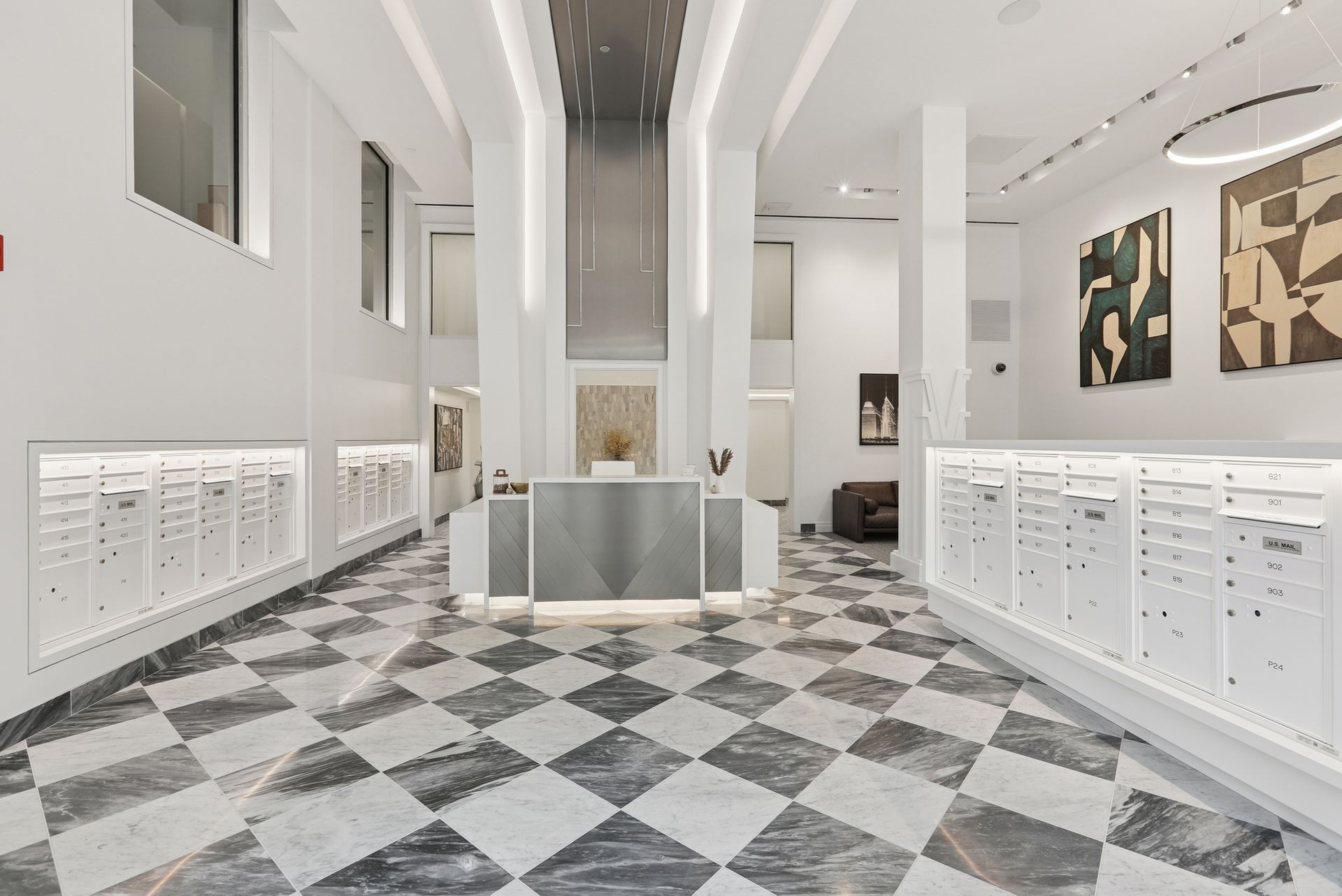 Elegant lobby with checkered floor, mailboxes, and modern art.
