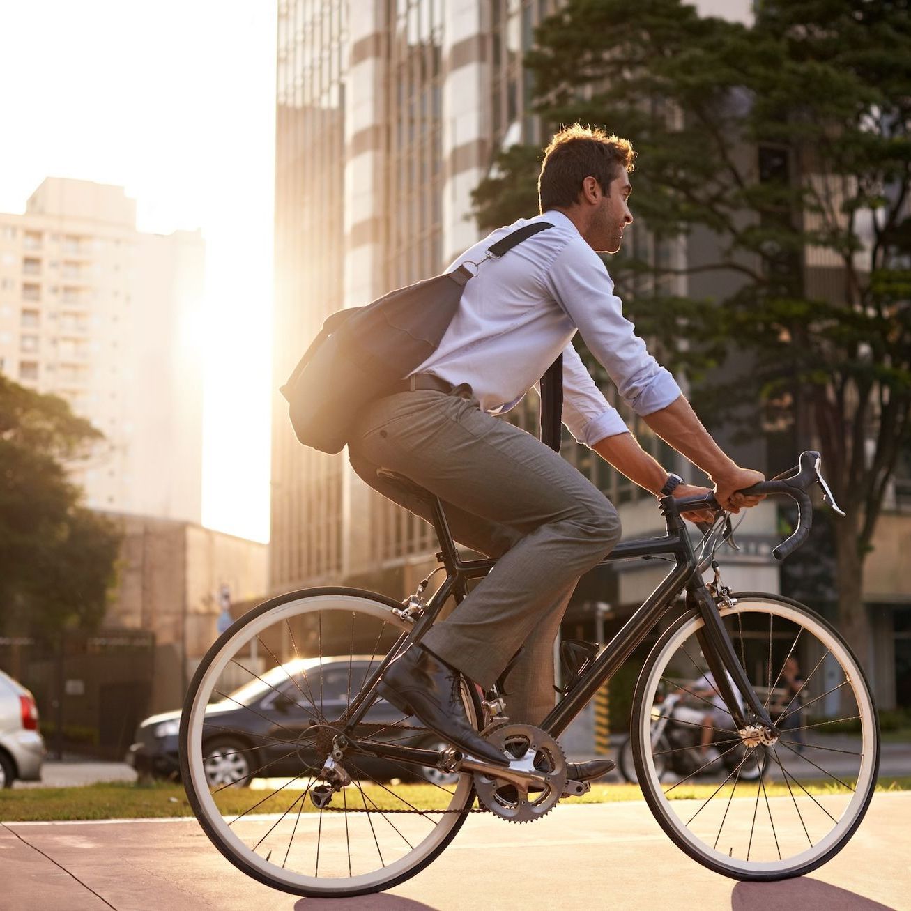A man is riding a bicycle down a city street.