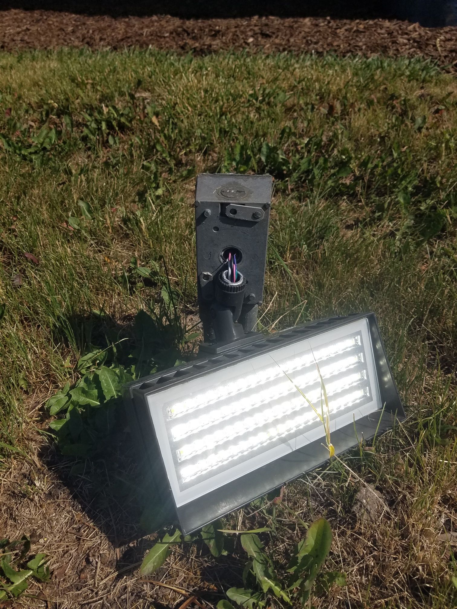 Two street lights are lit up against a cloudy sky at sunset