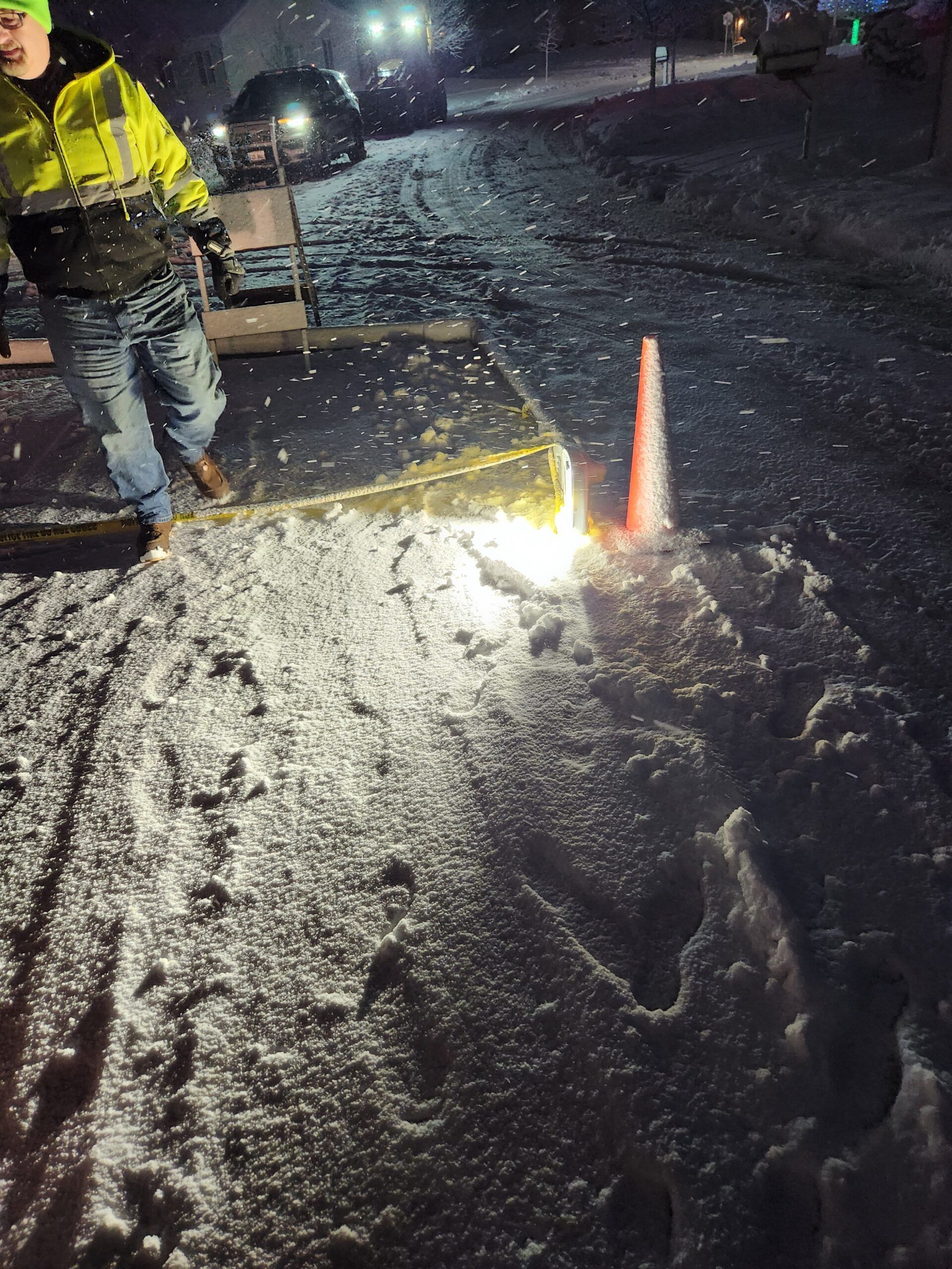 A man in a yellow jacket is standing in the snow